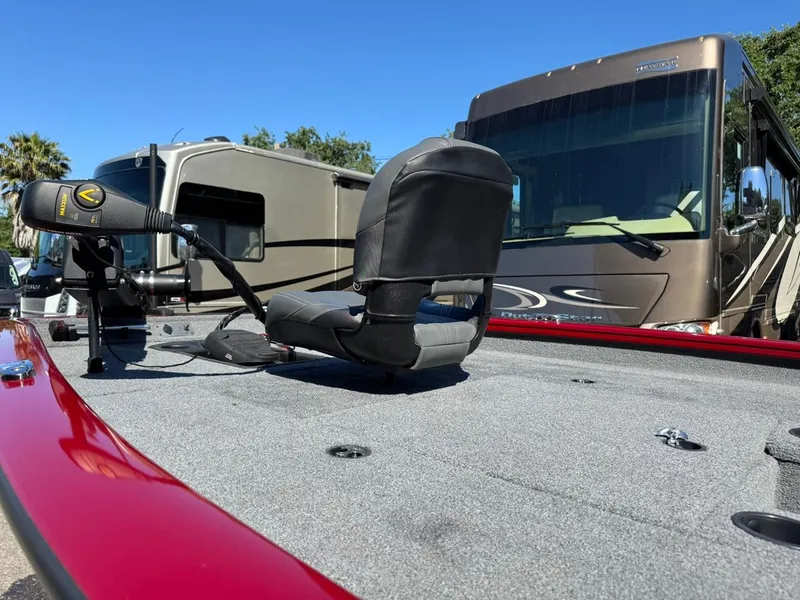 Slide: The Image of 2022 Tracker PRO TEAM 175 TWX boat deck with seat and motor, parked near RVs. - 8