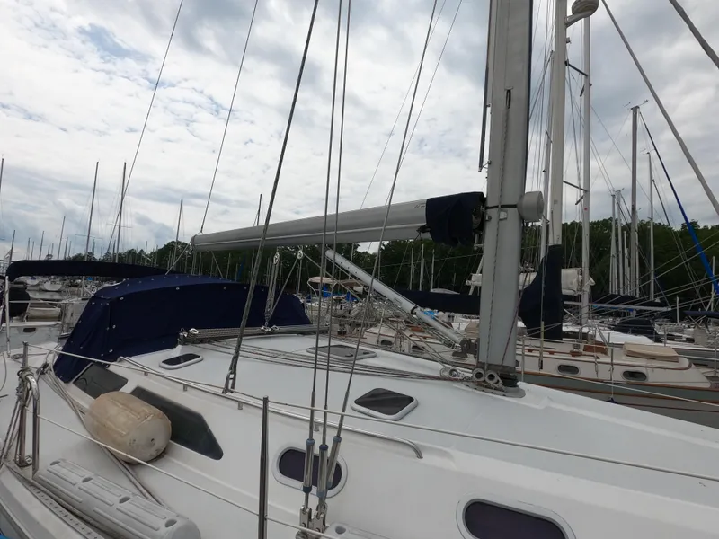 Slide: The Image of 2002 Catalina 42 MK11 sailboat docked in a marina, surrounded by other vessels. - 6