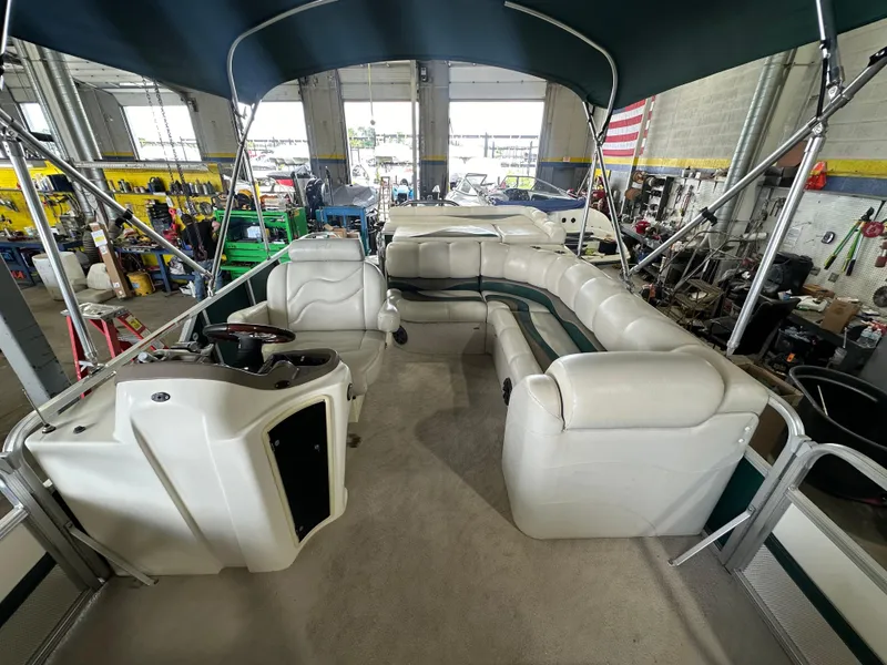 Slide: The Image of 2011 Avalon 2585 Paradise Tri Toon boat interior with seating and canopy in a workshop. - 3