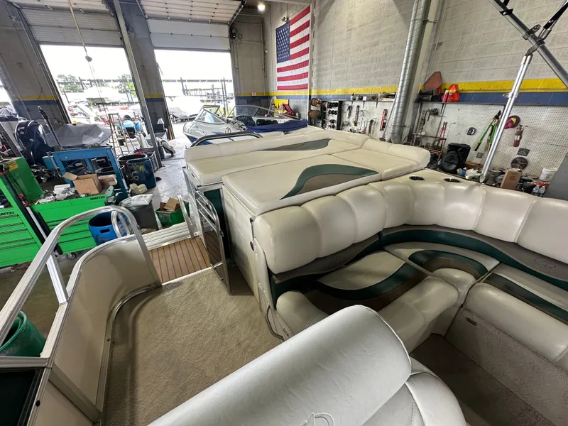 Slide: The Image of 2011 Avalon 2585 Paradise Tri Toon boat in a workshop with American flag. - 4