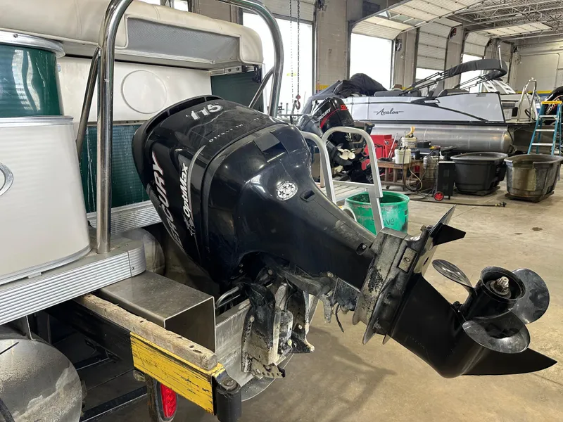 Slide: The Image of 2011 Avalon 2585 Paradise Tri Toon with outboard motor in a workshop setting. - 6