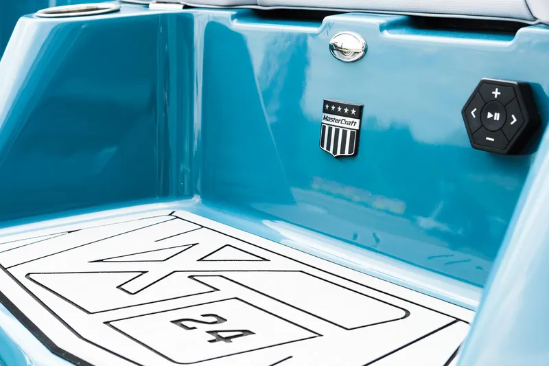 Slide: The Image of 2025 MasterCraft XT24 boat, blue exterior, close-up of branding and control panel. - 11