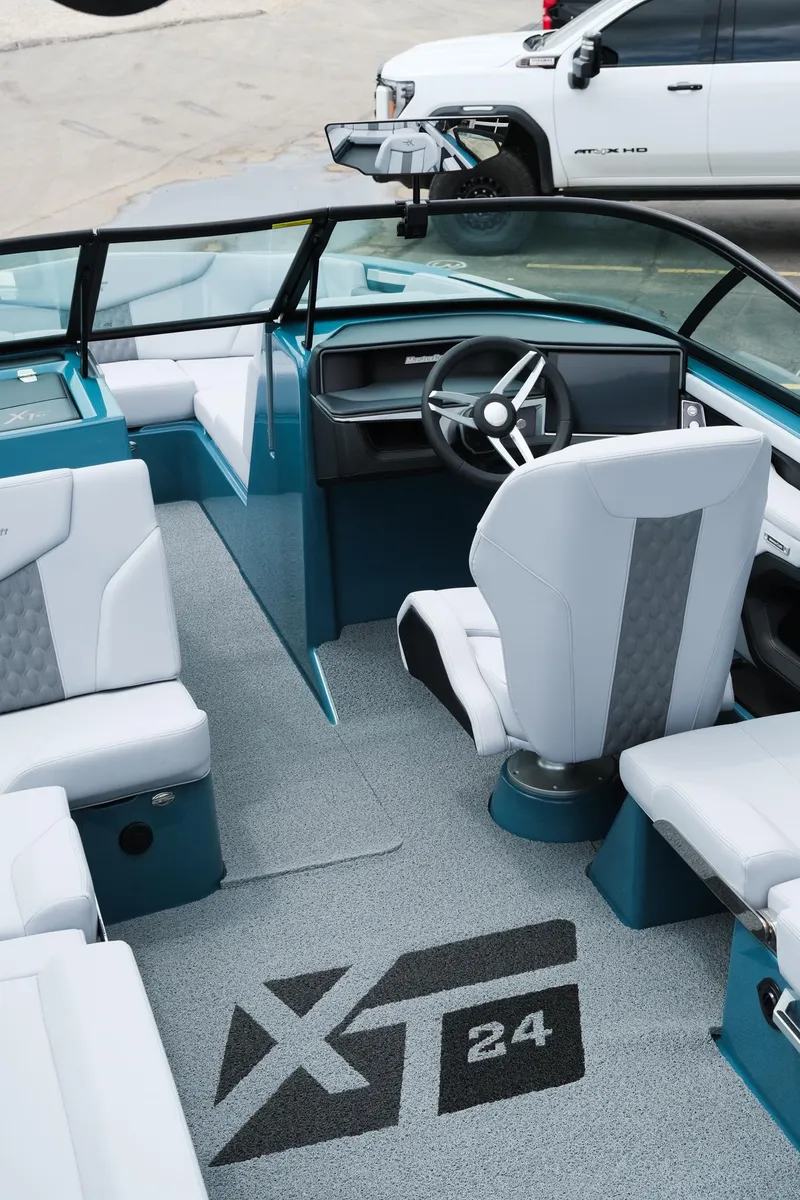 Slide: The Image of 2025 MasterCraft XT24 boat interior with modern seating and steering, featuring sleek design elements. - 18