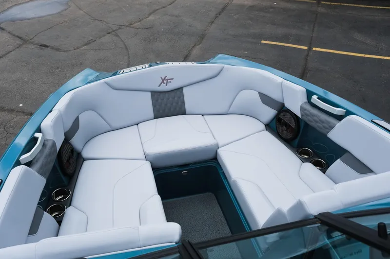 Slide: The Image of 2025 MasterCraft XT24 boat interior with white seating and cup holders. - 25