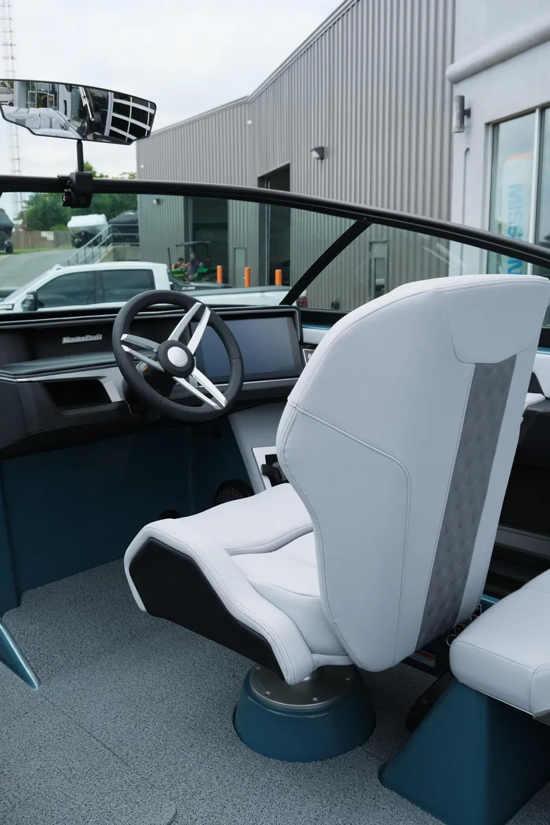 Slide: The Image of 2025 MasterCraft XT24 boat interior with modern steering and white captain's chair. - 26