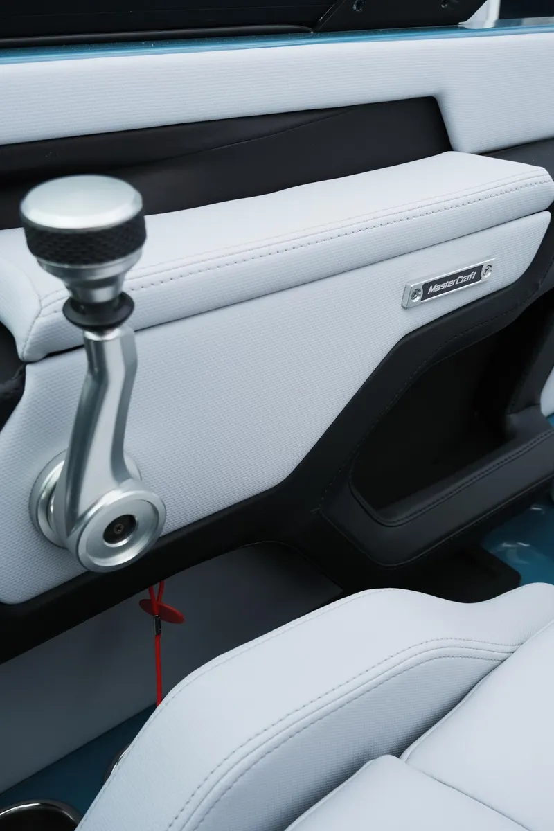 Slide: The Image of 2025 MasterCraft XT24 interior with sleek white upholstery and modern control lever. - 28