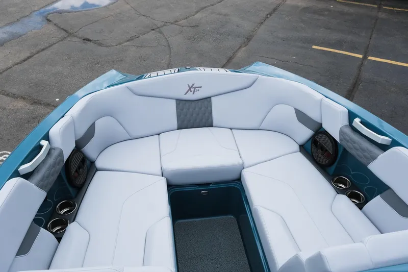 Slide: The Image of 2025 MasterCraft XT24 boat interior with white seating and cup holders. - 31