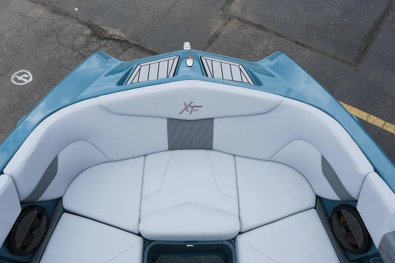 Slide: The Image of 2025 MasterCraft XT24 boat interior with white seating and blue accents. - 32
