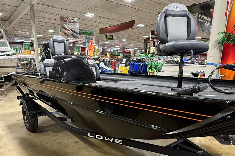 Slide: The Image of 2025 Lowe Legacy boat displayed indoors, featuring sleek black design and comfortable seating. - 0