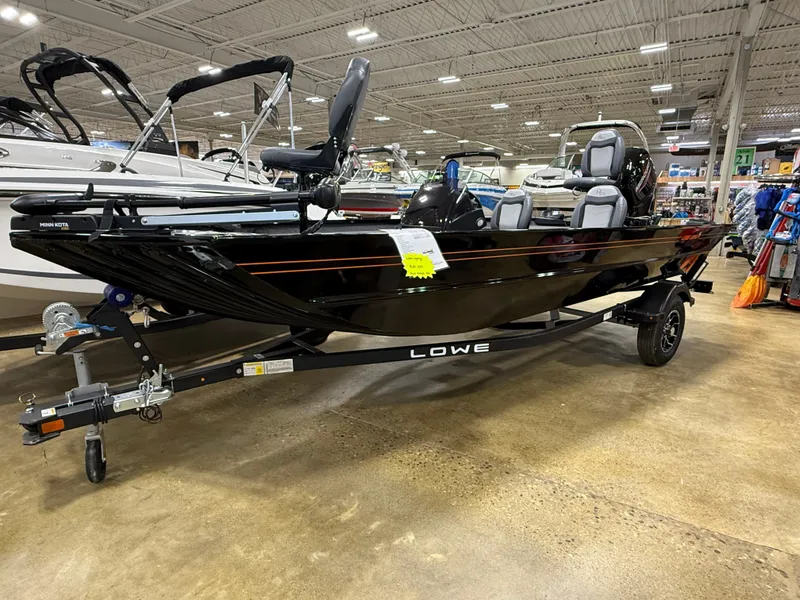 Slide: The Image of 2025 Lowe Legacy boat on display in a showroom, featuring sleek black design. - 1