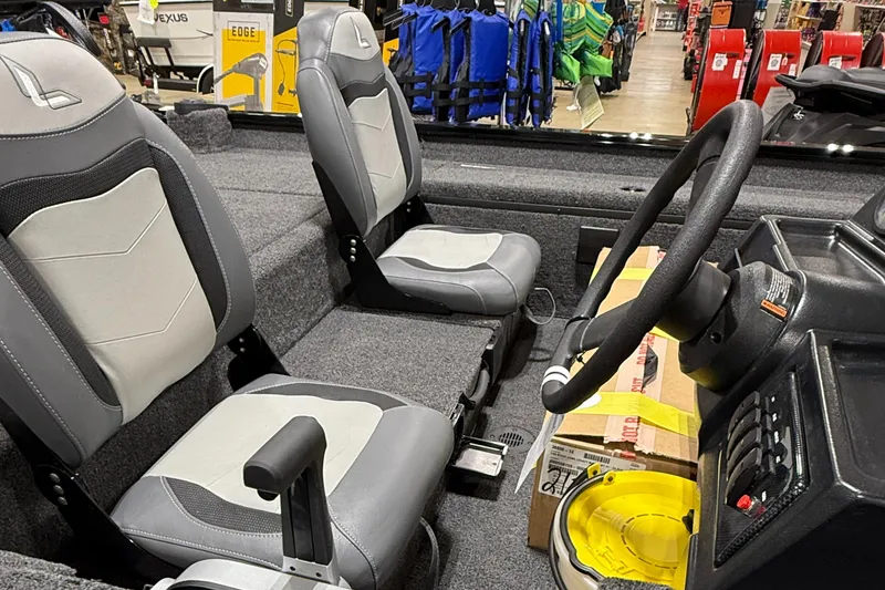 Slide: The Image of 2025 Lowe Legacy boat interior with gray seats and steering wheel in showroom. - 4