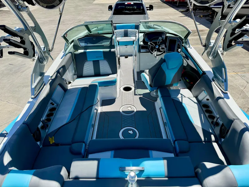 Slide: The Image of 2019 MasterCraft X22 boat interior with blue and gray seating, steering wheel, and dashboard. - 6