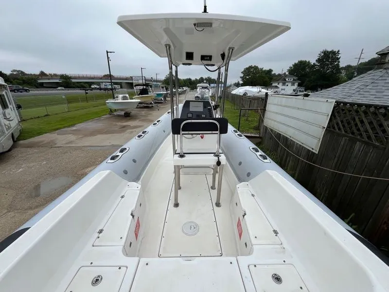 Slide: The Image of 2019 Apex A-24 boat with center console and seating, docked outdoors. - 3