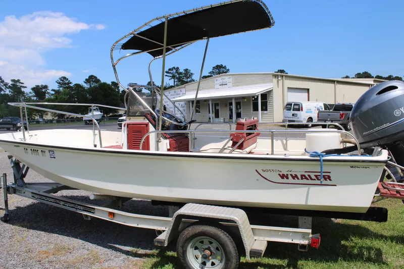 Slide: The Image of 1982 Boston Whaler 17 Montauk boat on trailer, with canopy, parked outdoors. - 10