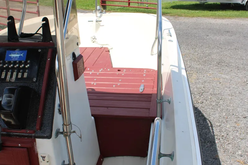 Slide: The Image of 1982 Boston Whaler 17 Montauk boat interior with red seating and control panel. - 20