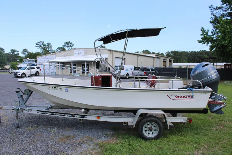 Slide: The Image of 1982 Boston Whaler 17 Montauk boat on trailer, parked outdoors near buildings. - 4