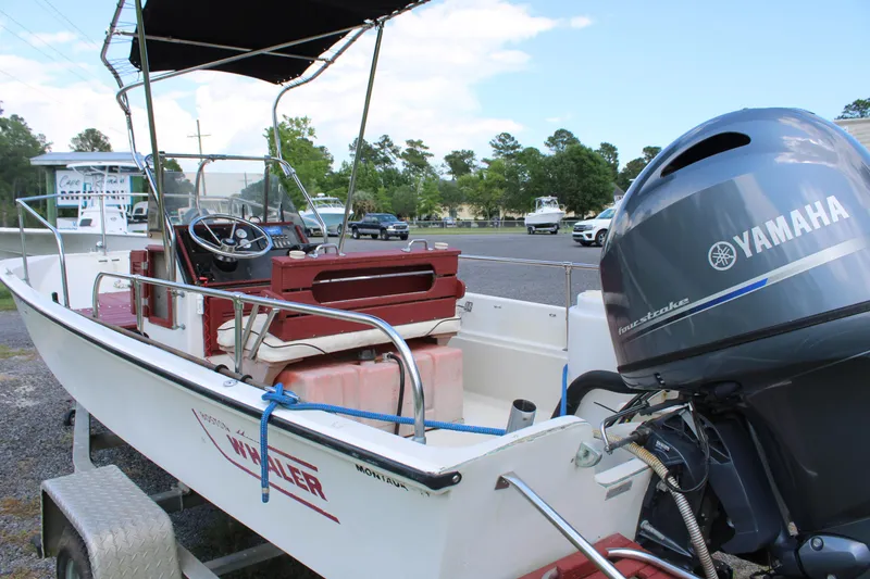 Slide: The Image of 1982 Boston Whaler 17 Montauk boat with Yamaha outboard motor in a parking lot. - 8