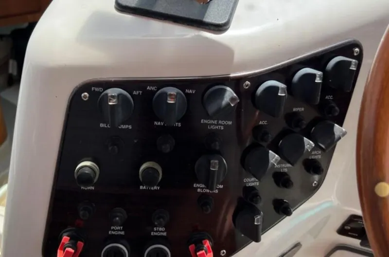 Slide: The Image of Control panel of a 2004 Chris-Craft 33 Express boat with various switches and knobs. - 23