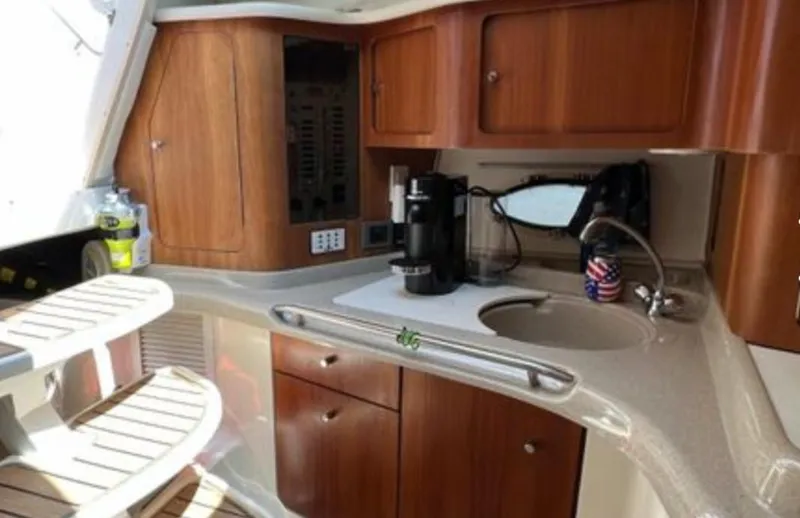 Slide: The Image of 2004 Chris-Craft 33 Express yacht interior with wooden cabinets and kitchenette. - 27