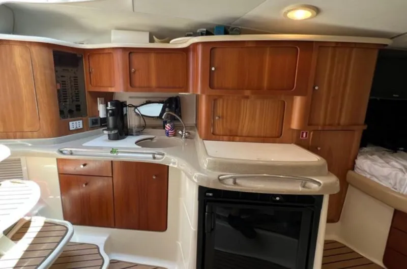 Slide: The Image of 2004 Chris-Craft 33 Express yacht interior with wooden cabinets and compact kitchen area. - 29