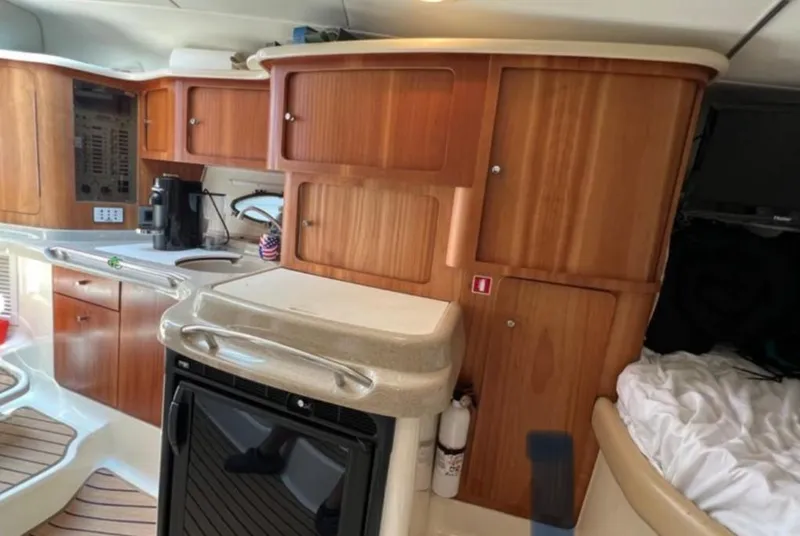 Slide: The Image of 2004 Chris-Craft 33 Express yacht interior with wooden cabinets and modern amenities. - 30