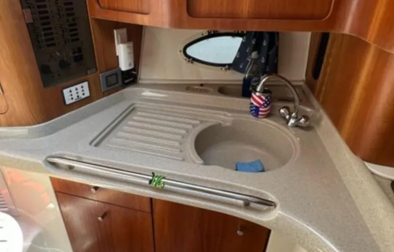 Slide: The Image of 2004 Chris-Craft 33 Express boat kitchen with sink and wooden cabinetry. - 33
