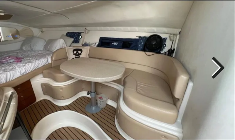 Slide: The Image of Interior of 2004 Chris-Craft 33 Express with beige seating, table, and bed. - 34