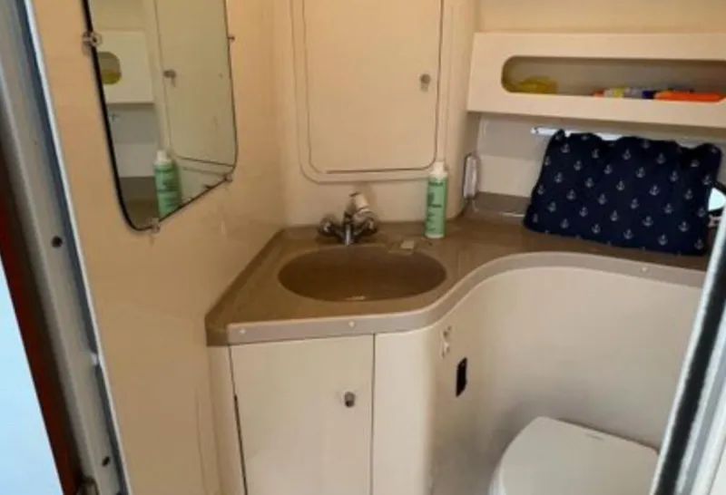 Slide: The Image of 2004 Chris-Craft 33 Express bathroom with sink, mirror, and storage shelves. - 43