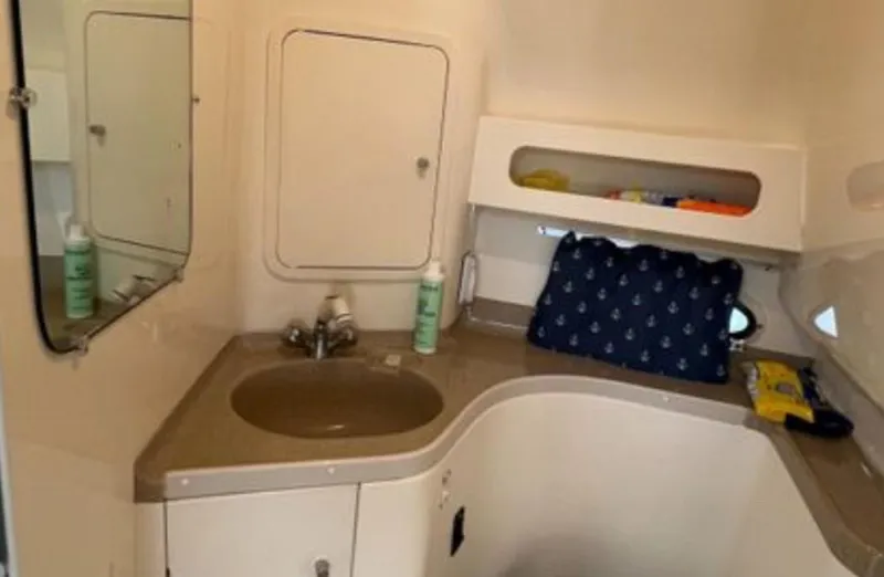 Slide: The Image of 2004 Chris-Craft 33 Express bathroom with sink, mirror, and storage shelves. - 44