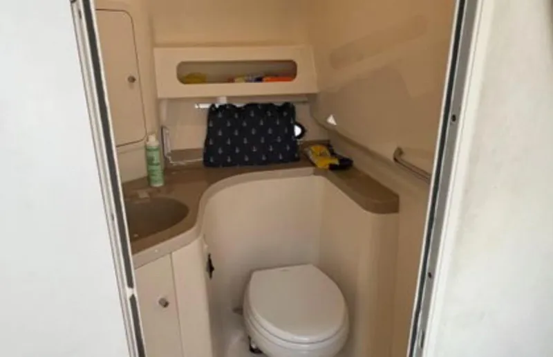 Slide: The Image of 2004 Chris-Craft 33 Express boat bathroom with sink, toilet, and storage shelves. - 45