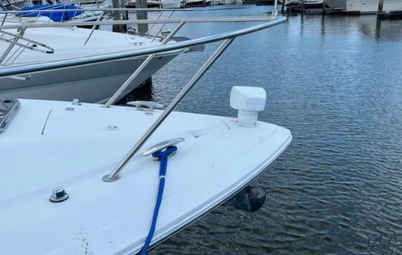 Slide: The Image of 2004 Chris-Craft 33 Express boat docked in marina, featuring sleek bow design. - 6