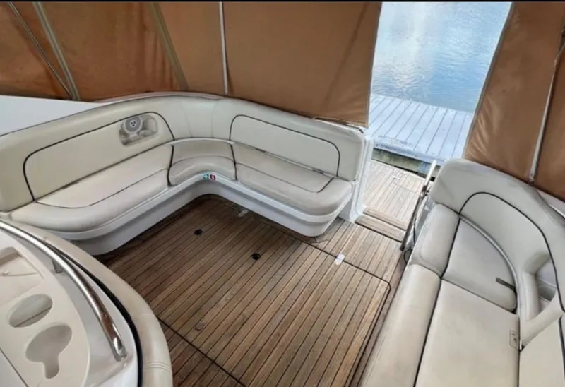 Slide: The Image of 2004 Chris-Craft 33 Express boat interior with beige seating and wooden flooring. - 7