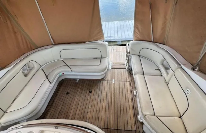 Slide: The Image of 2004 Chris-Craft 33 Express boat interior with beige seating and wooden deck. - 8