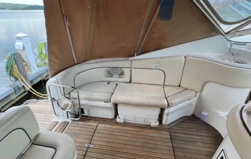 Slide: The Image of 2004 Chris-Craft 33 Express boat interior with beige seating and wooden deck. - 9