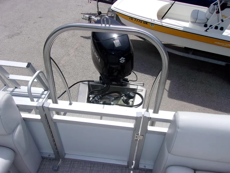 Slide: The Image of 2022 Avalon VLS Quad Lounger boat with outboard motor, viewed from the rear. - 10