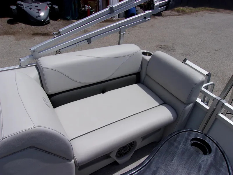 Slide: The Image of 2022 Avalon VLS Quad Lounger boat seat, gray upholstery, cup holder, outdoor setting. - 9