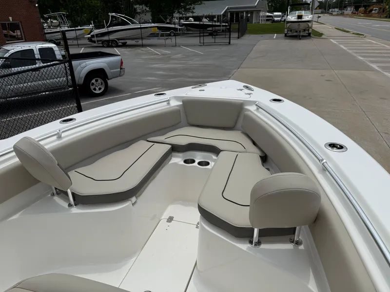 Slide: The Image of 2025 Key West 239 FS boat with spacious seating and modern design in a parking area. - 13