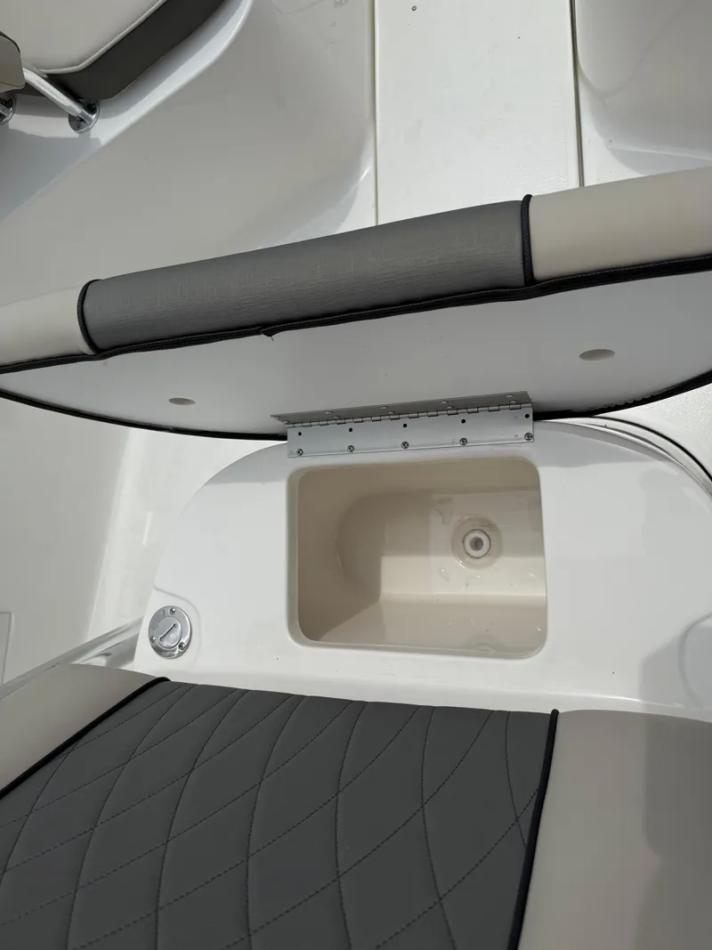 Slide: The Image of 2025 Key West 239 FS boat seat with storage compartment, open lid, and cushioned seating. - 19