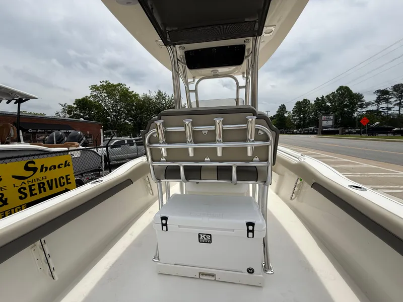 Slide: The Image of 2025 Key West 239 FS boat interior with seating and cooler, parked outdoors. - 25