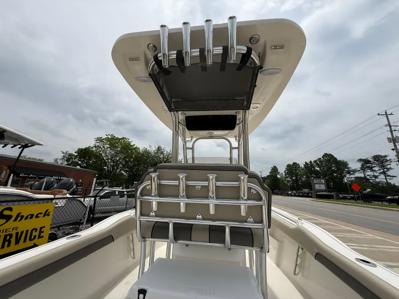 Slide: The Image of 2025 Key West 239 FS boat interior with rod holders and seating, under cloudy sky. - 26