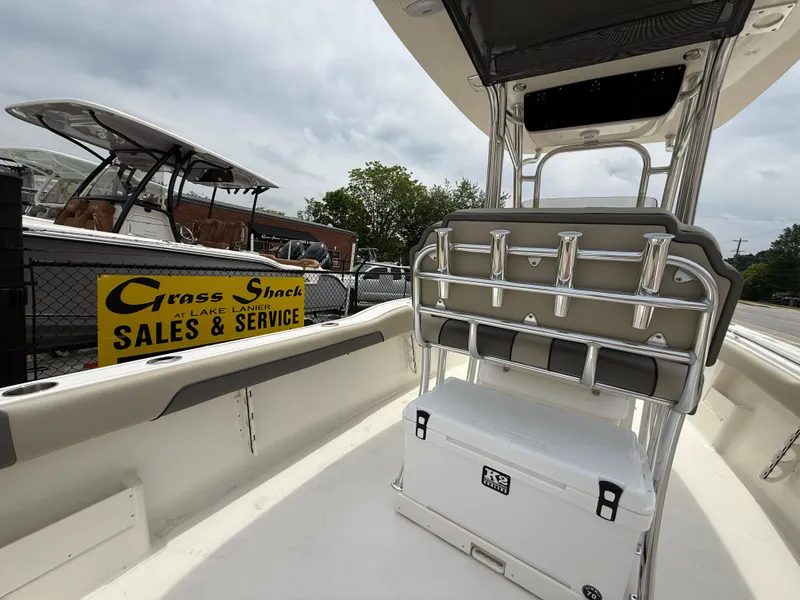 Slide: The Image of 2025 Key West 239 FS boat interior with seating and cooler, near sales and service sign. - 27
