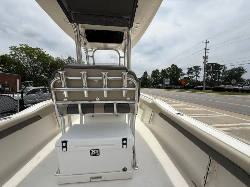 Slide: The Image of 2025 Key West 239 FS boat interior with seating and cooler, parked near a road. - 28