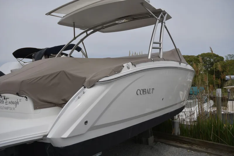 Slide: The Image of 2017 Cobalt R7 boat with cover, docked outdoors, featuring sleek design and ladder. - 1