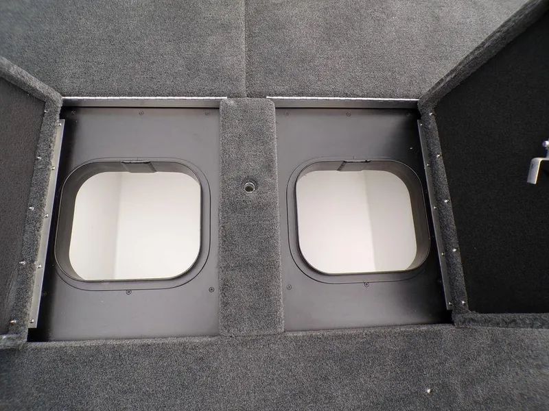 Slide: The Image of 2025 Skeeter ZXR21SE boat storage compartments with open hatches, featuring carpeted interior. - 25