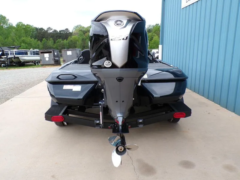 Slide: The Image of 2025 Skeeter ZXR21SE boat, rear view, parked on concrete near blue building. - 3