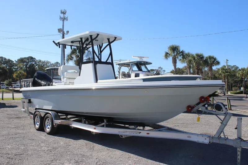 Slide: The Image of 2025 East Cape 25 Open boat on trailer, parked outdoors under clear blue sky. - 2
