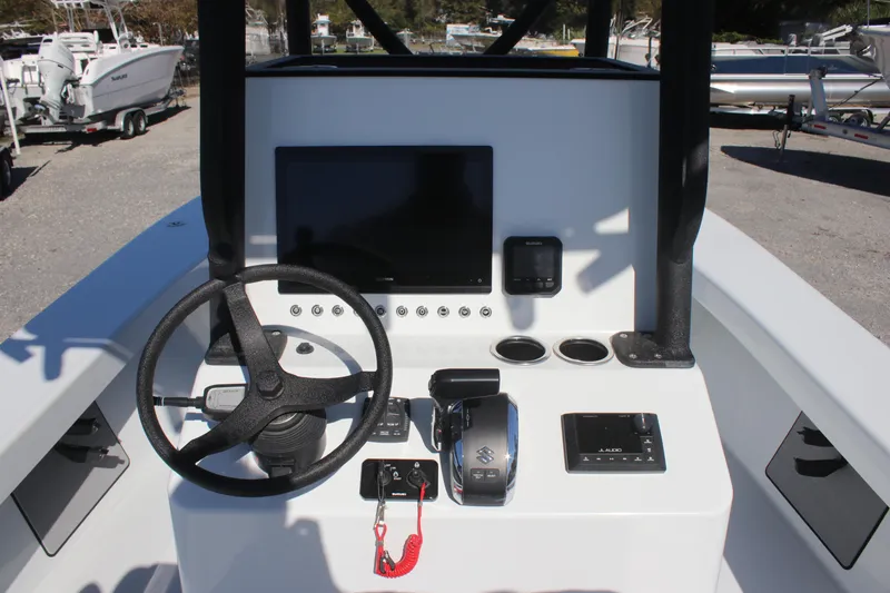 Slide: The Image of 2025 East Cape 25 Open boat dashboard with steering wheel and electronic controls. - 7