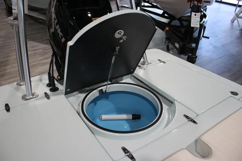 Slide: The Image of 2025 East Cape EVO 18V boat with open livewell and motor in showroom. - 11