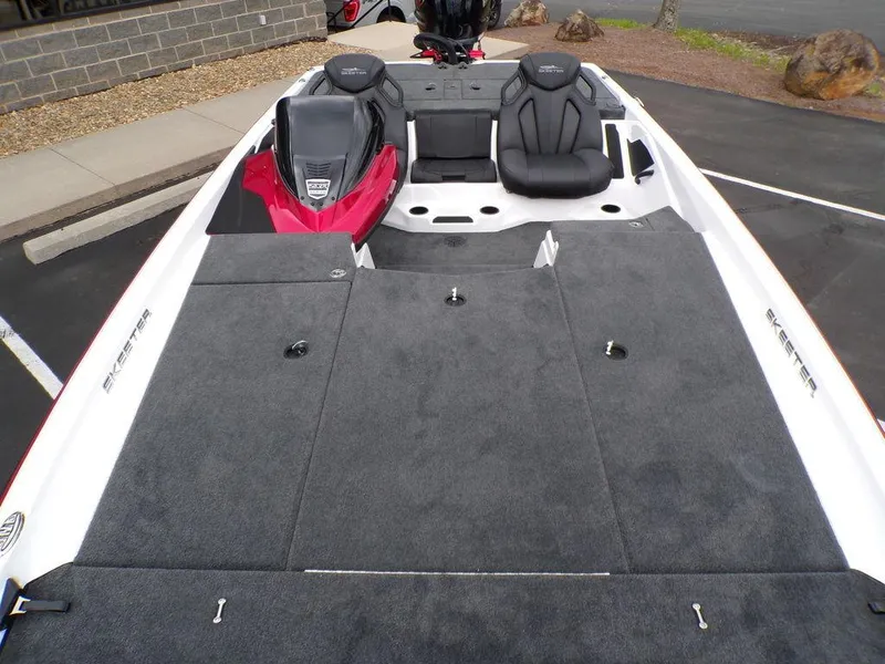 Slide: The Image of 2025 Skeeter ZXR21SE boat interior with gray carpet and black seats. - 12