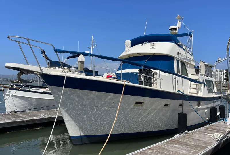 Slide: The Image of 1976 Hatteras 48 LRC yacht docked at marina under clear blue sky. - 1